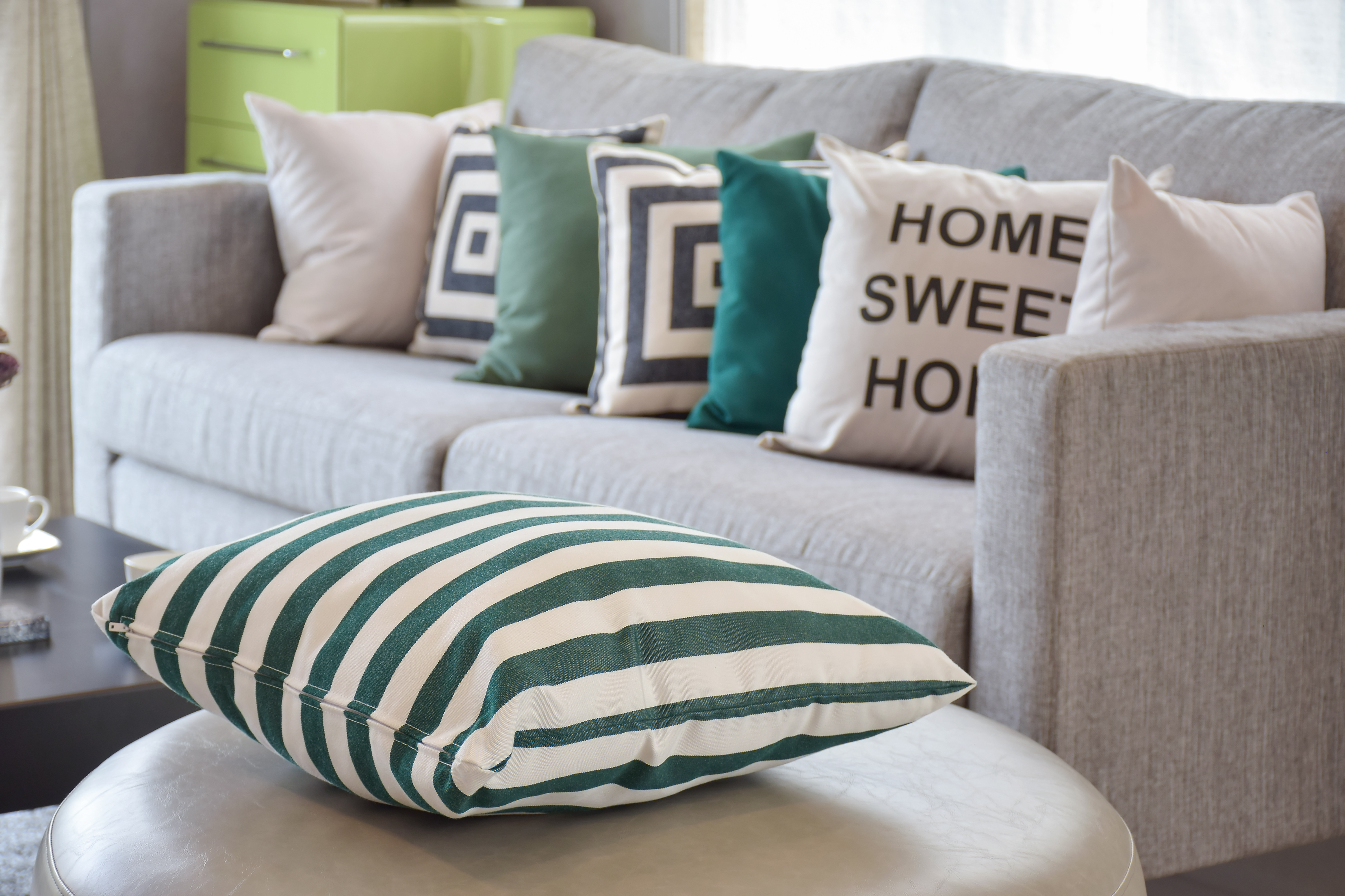 green striped pillows on the cozy grey sofa in the living room